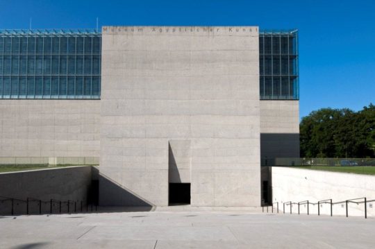 Eingangstreppe des Museums. Die Treppe führt hinunter zu einer großen Portalwand.