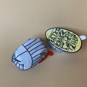 Ein aus Papier gebastelter Skarabäus, blau und gelb bemalt