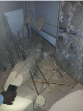 In einem demolierten Museumsraum liegt eine zerbrochene Statue am Boden