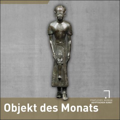 Bronzestatue eines stehenden, kahlköpfigen Mannes, der eine Statue des Osiris vor sich hält